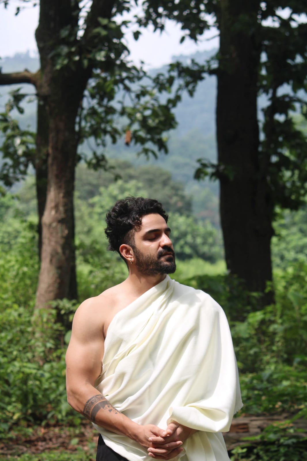 Aditya Chamoli standing outdoors, eyes closed, in a calm moment