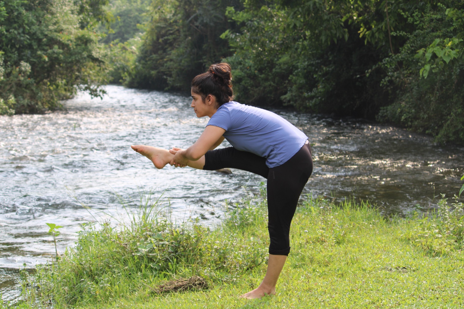 Practitioner stretching calmly by a quiet river