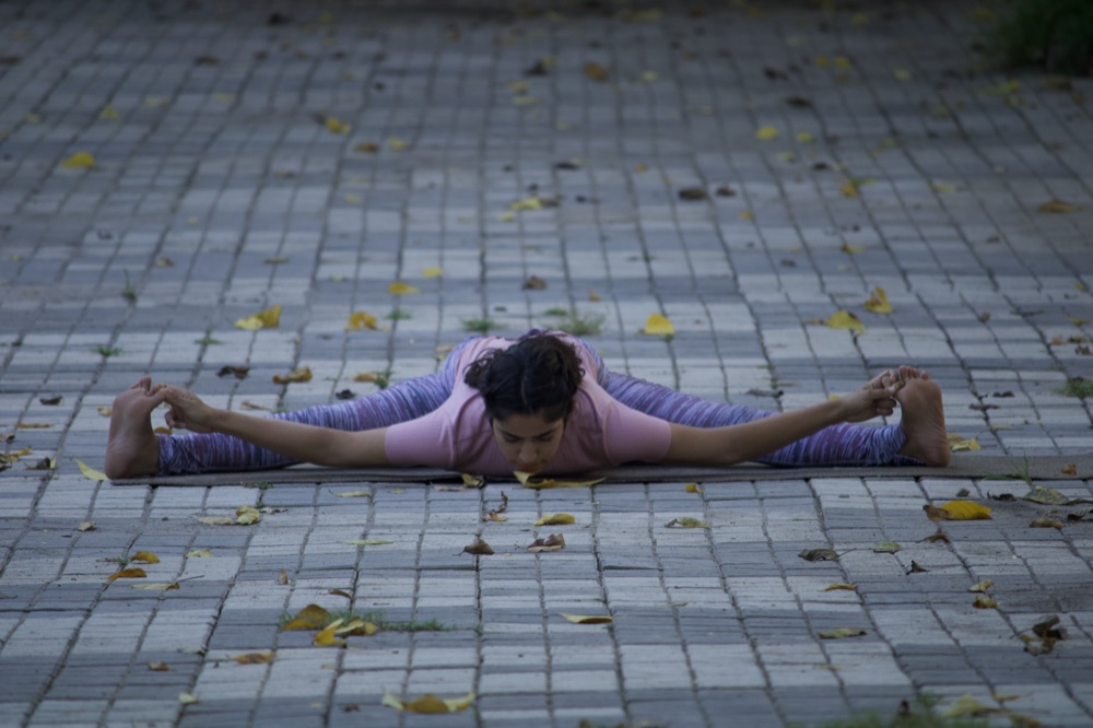 Practitioner in a gentle seated postnatal recovery stretch